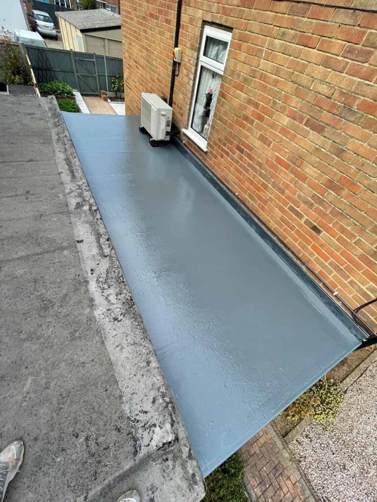 This is a photo of a newly installed liquid flat roof which has been completed to a very high standard and finished in grey colour. It is installed on a garage roof.