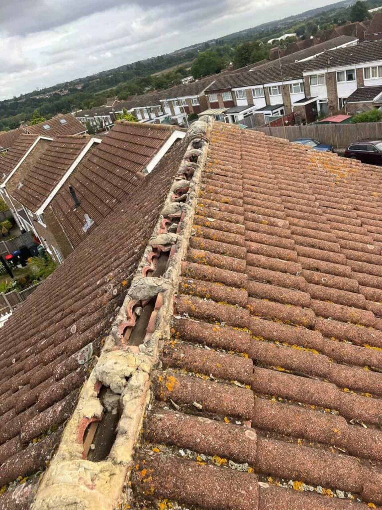 This is a photo taken on the top of a roof that shows the ridge which has been stripped and is waiting for the ridge tiles to be renewed